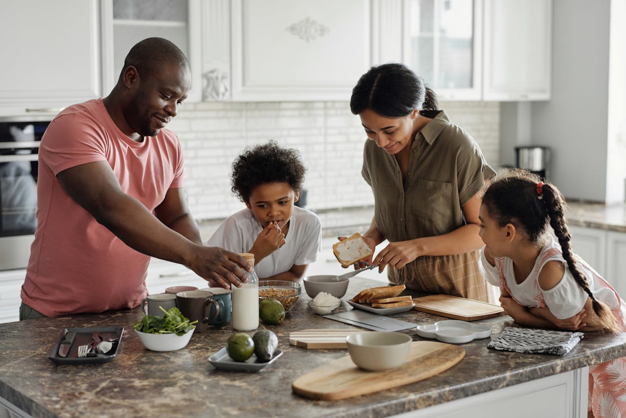 A Welsh host family making breakfast together in a bright kitchen — the morning immersion experience for visiting students