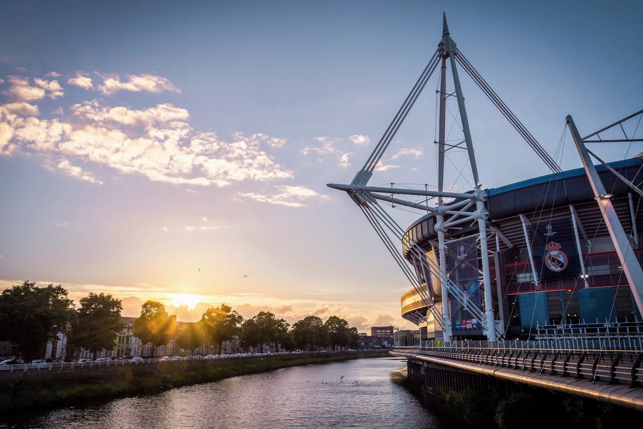 Principality Stadium reflected in the River Taff at sunset, Cardiff — home of Welsh rugby and a highlight of the school trip itinerary